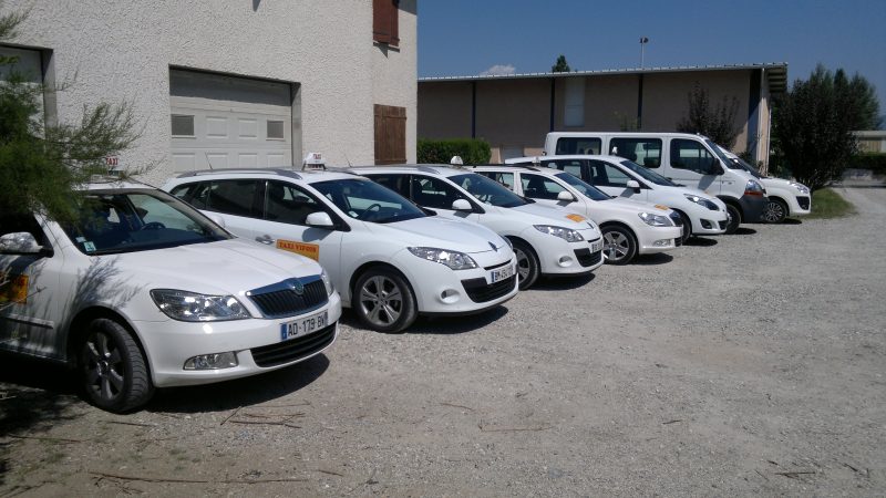 La flotte de taxis blancs Taxi Vifois garée devant les locaux de Vif